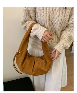 Detail of caramel suede hobo bag featuring drawstring fold and elegant matte texture
