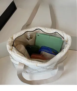 Spacious interior of white quilted tote bag showing capacity for iPad and daily essentials