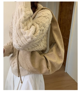 Close-up of the beige hobo shoulder bag texture and seamless strap design on a model