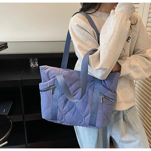Detailed quilted puffer tote bag with side silver zippers and sleek nylon texture