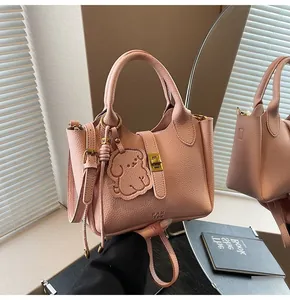 Detail of pink lychee leather handbag with golden hardware and cute puppy charm accessory