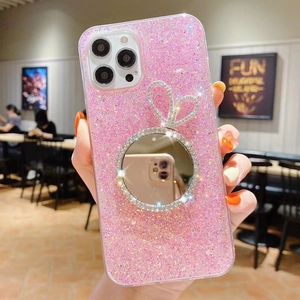 Pink glitter phone case for iPhone featuring a mirror stand and cute bunny ear detail