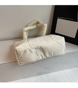 Dettaglio della borsa tote trapuntata in nylon crema con morbida texture imbottita