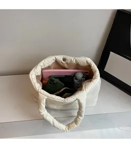 Interno spazioso della borsa tote trapuntata con oggetti quotidiani come un tablet