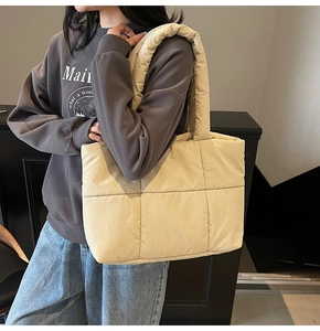 Dettaglio della borsa tote trapuntata beige con cuciture ampie e tracolla morbida imbottita