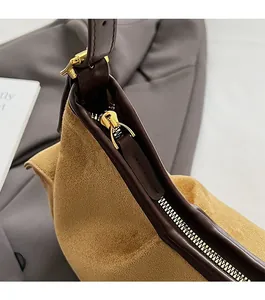 Détail de la fermeture éclair dorée et de la texture en daim sur un sac à main vintage