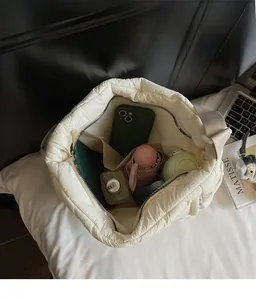 Top view of cream quilted tote bag showing large interior space and side pocket