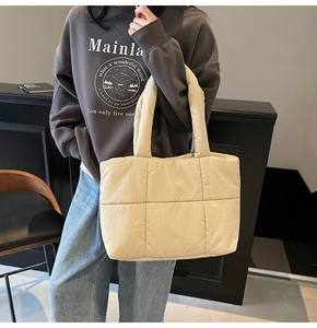 Dettaglio della borsa tote trapuntata beige con manici larghi e tessuto morbido