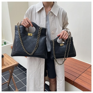 Detail of black quilted leather handbags with golden twist locks and chain straps