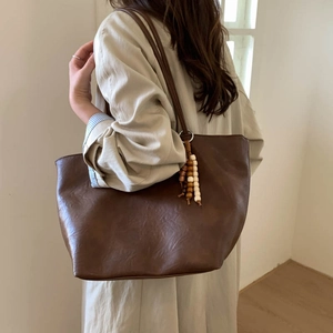 Deep brown oversized tote bag in soft faux leather with vintage wooden bead tassel detail