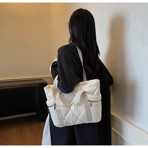 Detailed back view of a white quilted tote bag with diamond stitching and nylon straps