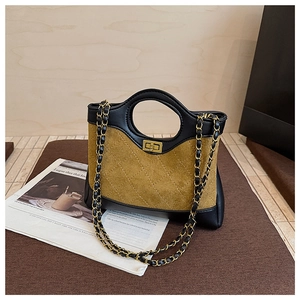 Detail of color-block leather bag featuring diamond stitching and gold turn-lock closure