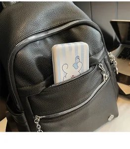 Detail of black lychee grain leather backpack with silver zippers and multi-layer storage