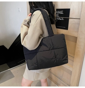 Dettaglio laterale della borsa tote trapuntata nera con ampi spallacci in nylon