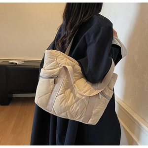 Quilted tote bag detail featuring large capacity, beige rhombic stitching and side zipper