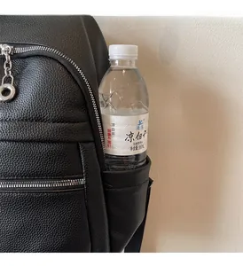 Close-up of side pocket on black pebble leather backpack holding a 550ml water bottle