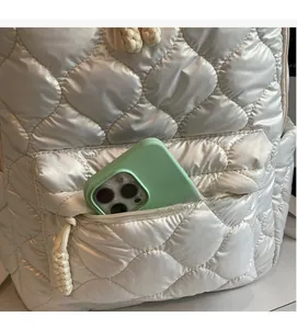 Detailed view of the quilted backpack front pocket showing space for a smartphone