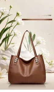 Detail of caramel brown lychee texture leather tote bag with silver N-shaped metal hardware