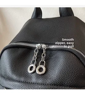 Detail of smooth silver zippers and cat ear design on a black leather backpack
