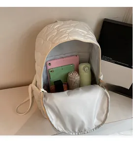 Spacious interior of white quilted backpack holding a tablet, water bottle and umbrella