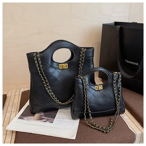 Detail showing two sizes of black quilted leather handbags with golden chain straps