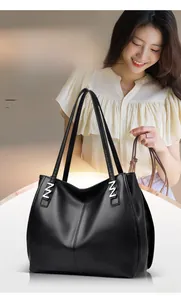 Detail of premium black lychee grain leather tote bag with silver N-shaped metal buckles