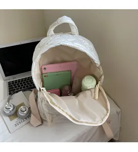 Interior view of large white quilted backpack showing spacious storage and item capacity