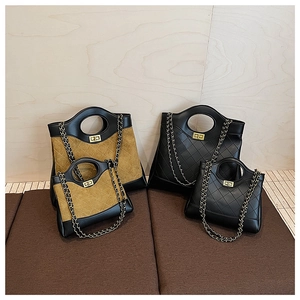 Detail of quilted leather and suede tote bags with circular handles and metal chain straps