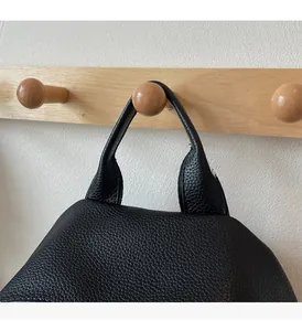 Close-up of the comfortable and durable black lychee texture leather top handle