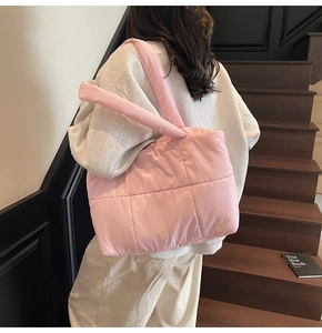 Dettaglio della borsa tote trapuntata rosa con trama in nylon e manici imbottiti morbidi