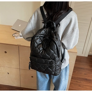 Close-up of black quilted heart backpack with durable nylon straps and woven zipper detail