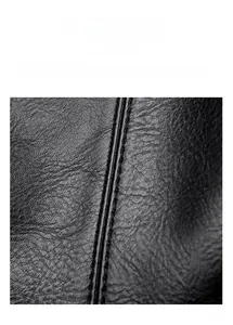 Macro shot of precise stitching and litchi texture on black leather shoulder bag