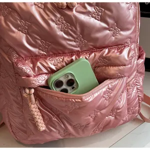 Detail of pink padded backpack showing spacious front zip pocket for a smartphone