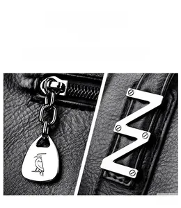 Detail of silver hardware bird zipper and V-shaped metallic latch on black lychee leather