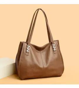 Detail of brown tote bag featuring lychee grain leather and silver N-shaped metal buckle