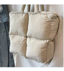 Close-up of beige quilted down tote bag with soft padded square stitching and light nylon