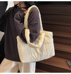 Dettaglio della borsa tote trapuntata beige con morbida trama in nylon e tracolla imbottita