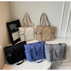 Five colors of large quilted tote bags in white, khaki, black, grey, and cobalt blue