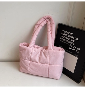 Dettaglio della borsa tote rosa trapuntata con manici morbidi e trama effetto piumino