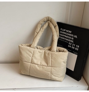 Dettaglio della borsa tote trapuntata beige con texture morbida e manici imbottiti
