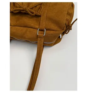 Détail du sac en daim caramel avec cordon à nœud et quincaillerie en anneau argenté