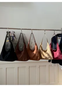 Close-up of five colorful suede hobo tote bags with wide straps for women