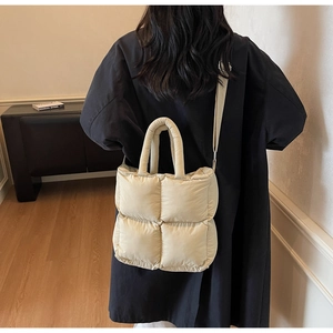 Quilted tote bag in off-white finish showing dual handles and detachable shoulder strap