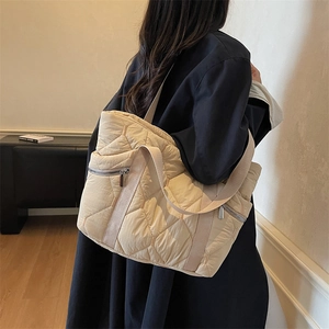 Beige quilted tote bag for women with diamond stitch patterns and a wide shoulder strap