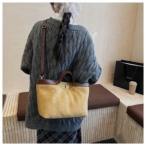 Détail du sac fourre-tout matelassé jaune avec fermoir rotatif et finitions cuir