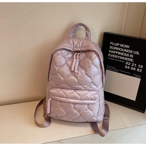 Close-up of quilted light purple nylon backpack showing front pocket and rope zipper pull