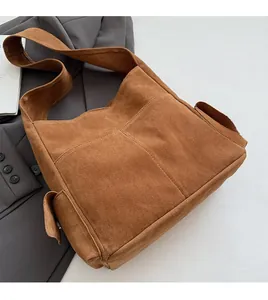 Détail d'un cabas en daim carmélis doux avec poches sur un blazer gris chic