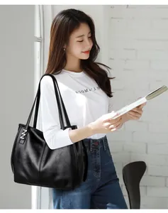 Detail of matte black leather tote bag with silver hardware and textured finish