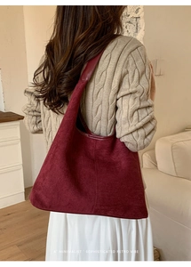 Minimalist large burgundy suede tote bag shown on shoulder with retro vibe and soft texture