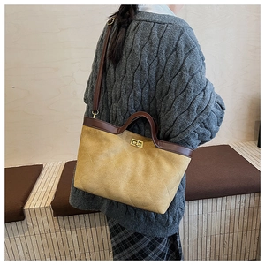 Détail du sac cabas matelassé en daim moutarde avec garniture en cuir et fermoir doré